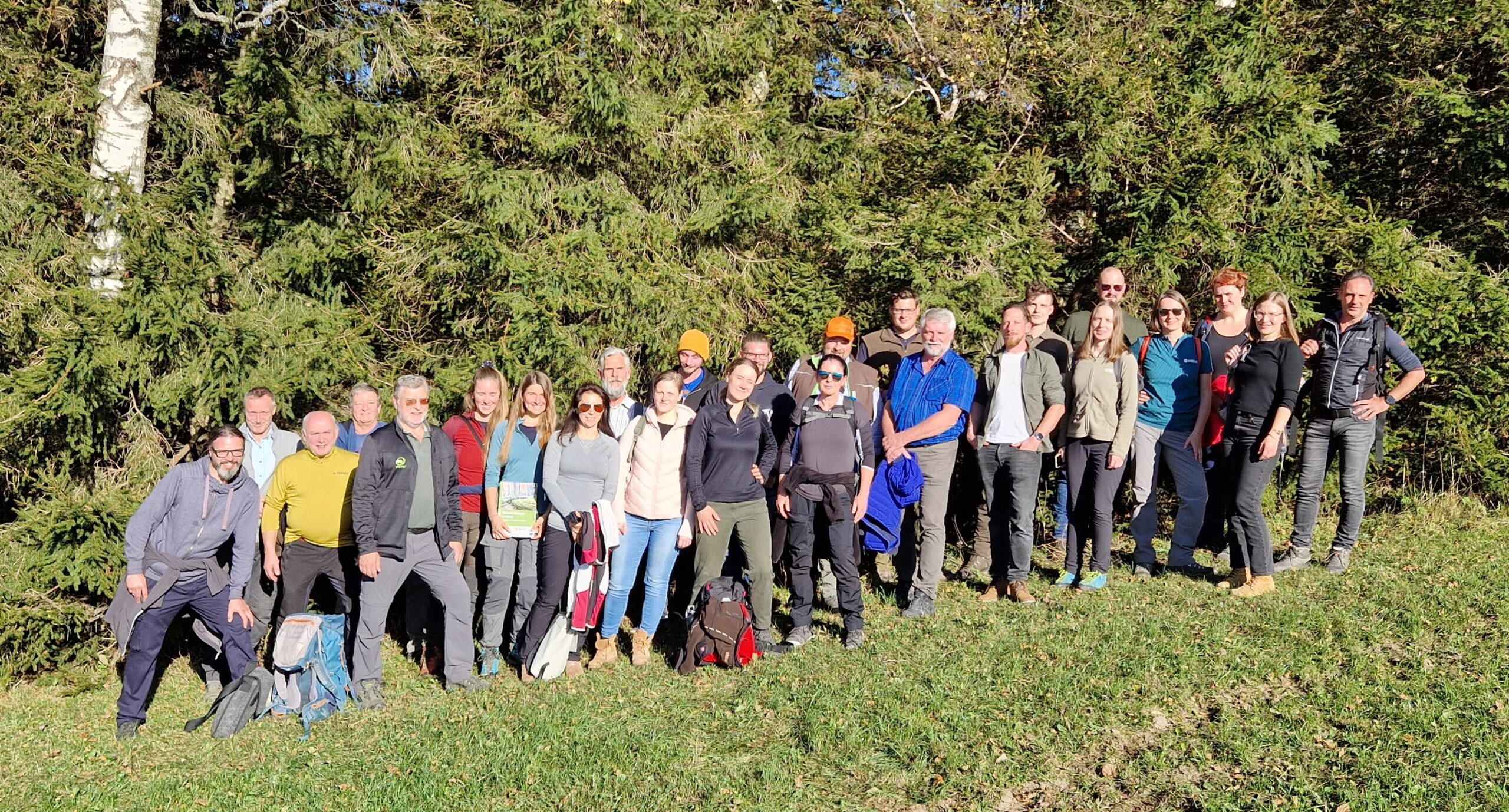 Gruppenfoto auf einer Wiese vor einem Wald