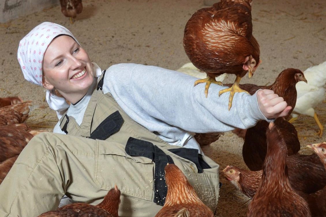 Frau mit Hühnern am Boden liegend