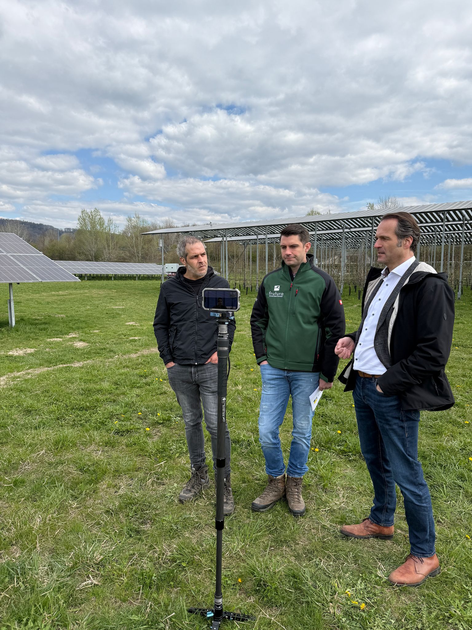 Die Referenten des Farminars stehen vor einer PV-Anlage.